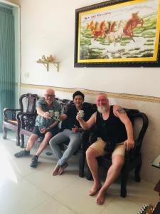 芹苴Huy Hoàng Motel - Cần Thơ的坐在长凳上的三人组