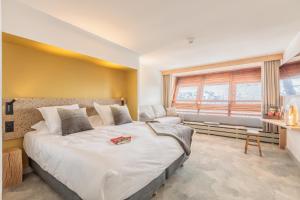 阿克 1600La Cachette, Friendly Hotel & Spa的一间卧室设有一张大床和一个窗户。