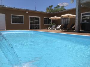 CapanemaHotel Tito's的一座大蓝色游泳池,位于房子前