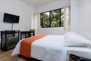 瓜亚基尔阿尔伯拉达酒店的一间卧室配有一张床和一台平面电视