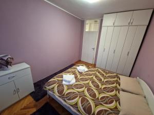 波德戈里察Your place in Podgorica的一间小卧室,配有一张床和白色橱柜
