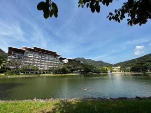 CutadBonel condo at Pico de Loro的一座建筑,毗邻一座以山脉为背景的湖泊