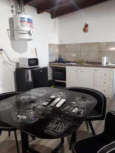 维多利亚Cabañas Atardecer en Victoria的厨房里一张黑桌,配有椅子和台面