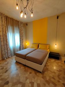 维琴察Zeljko's luxury hostel的一间卧室设有一张黄色墙壁的大床