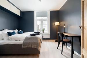 特隆赫姆Home away from home in Trondheim的一间卧室设有蓝色的墙壁、一张床和一张书桌
