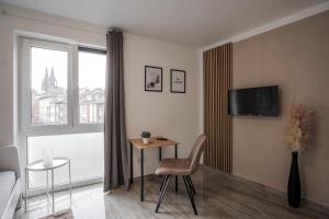科隆Apartments Cologne的客厅配有椅子、桌子和窗户