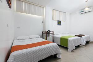 瓜亚基尔阿尔伯拉达酒店的白色墙壁客房的两张床