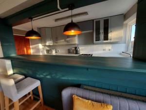 伦敦2 bed flat, Bounds Green, Piccadilly line, London N11的一间带酒吧的厨房和一张沙发