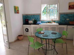 莫纳斯提尔Magnifique villa en Centre Ville的厨房配有桌子和绿色椅子