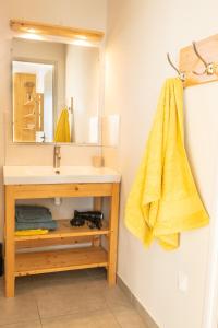 韦尔科尔地区朗Gite Le Rucher的一间带水槽和黄毛巾的浴室