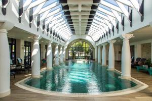 帕尔Santé Wellness Retreat & Spa的一座带玻璃天花板的建筑中的游泳池