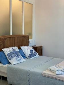 尼斯鸿兰德菲亚纳宫殿公寓的一间卧室配有两张带蓝白色枕头的床