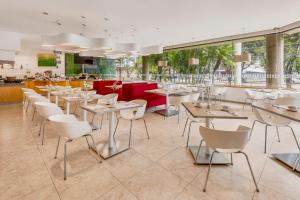 瓜达拉哈拉瓜达拉哈拉博览会嘉年华酒店的一间设有白色桌子和白色椅子的餐厅