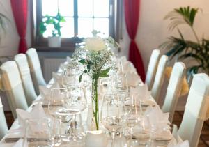 拉姆斯泰因-米森巴赫Hotel Rosenhof GmbH的长桌子,带眼镜和花瓶