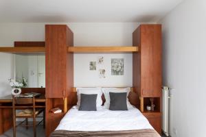 科尔特Appart Hotel Corte HR的一间卧室配有一张带木制床头板的床