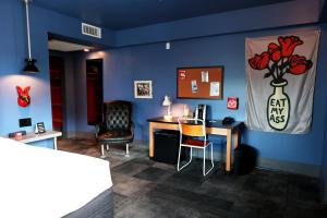 迈阿密海滩Hotel Gaythering - Gay Hotel - All Adults Welcome的一间卧室设有蓝色的墙壁、桌子和椅子