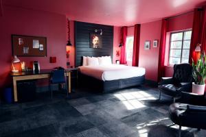 迈阿密海滩Hotel Gaythering - Gay Hotel - All Adults Welcome的红色的房间,配有一张床、一张桌子和椅子