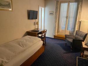 因特拉肯湖泊酒店的酒店客房配有一张床、一张书桌和一台电视。