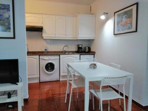 圣地亚哥海滩Casa Alisios的厨房配有白色的桌椅和洗衣机。