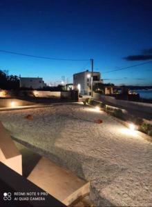 索瓦拉Oinoni's Home - ACHILLES studio的夜晚有灯光的石头庭院
