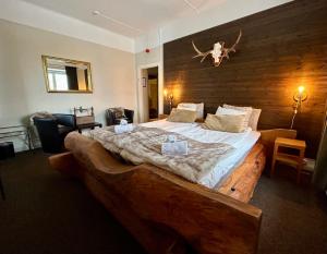 奥萨宫沙卡酒店的一间卧室配有一张大床和木制床头板