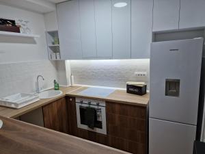 Nova PazovaCentar lux的厨房配有白色橱柜、水槽和冰箱。
