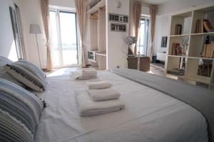 巴里Rossani Suites&Aparts的一张白色大床,上面有毛巾