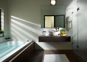 兹奇隆亚科夫贝特迈蒙酒店的带浴缸、水槽和镜子的浴室