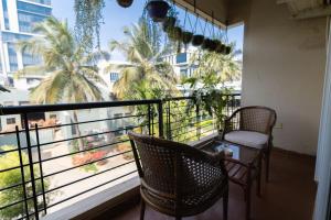 班加罗尔Luho 206的阳台配有两把椅子,享有棕榈树的景致。