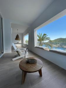 巴古尔Cap Sa Sal suites -Apartament Begur - Costa Brava的客厅设有桌子和大窗户