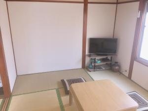 东京D-pdal Inn - Vacation STAY 39054v的一间空房间,设有两张桌子和电视
