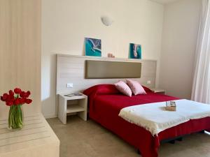 马瑟利Crystal Camere的一间卧室配有一张红色的床和花瓶