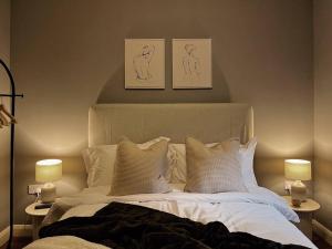 托德莫登Modern Ground Floor Apartment的一间卧室配有一张带枕头的床和两盏灯。