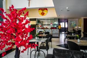 萨尔瓦多Hotel Piramide Pituba - Rua Pernambuco的一间带桌椅和红花的餐厅