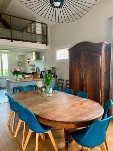 土伦VILLA PRESENCE - Chambres d'hôtes - Activités bien-être的一间带木桌和蓝色椅子的用餐室
