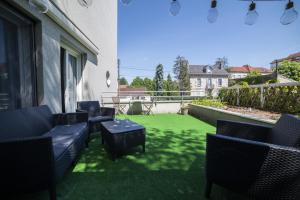 贝桑松L'île d'Olive, appartement entier 2 à 4 personnes terrasse 25 m2 Besançon, proche CV, Micropolis et CHU的一个带椅子的庭院和绿色草坪
