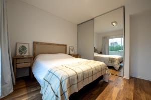 贝伦埃斯科巴Apartamento Amalfi的一间卧室设有两张床和大镜子