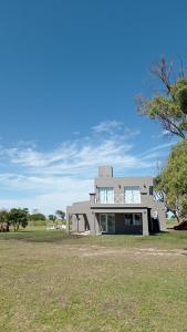奇基塔湖巴尔内阿里奥COMPLEJO LA ISLA MAR CHIQUITA的蓝天草场上的房屋