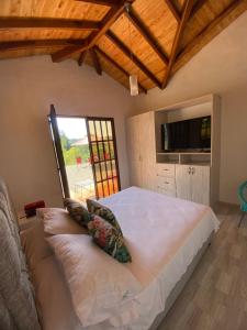 La FuenteFINCA VILLA CRISTINA的卧室设有一张白色大床和一扇窗户。