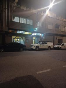 克辛索德利米亚Hotel 2 de mayo 2的两辆汽车在晚上停在加油站前