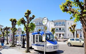 奥斯赛拜-塞林schöne Ferienwohnungen mit Kamin im Ostseebad Sellin Kopie的停在城市街道上的一辆蓝色和白色的公共汽车