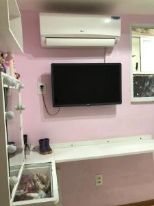 里约热内卢Cobertura com Piscina na Lapa的挂在粉红色墙壁上的平面电视