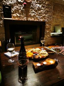 卡拉维塔塞弗洛普罗酒店的一张桌子,上面放着一瓶葡萄酒和两杯酒