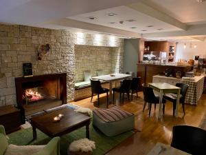 卡拉维塔塞弗洛普罗酒店的客厅设有壁炉、桌子和椅子