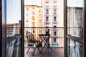 米兰Gegix's Rooms Milano的阳台配有桌椅,享有风景。