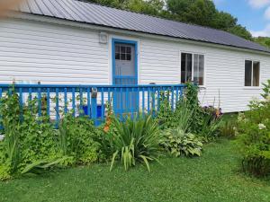 OtisBig Axe Bed & Breakfast的一座带蓝色栅栏和一些植物的房子