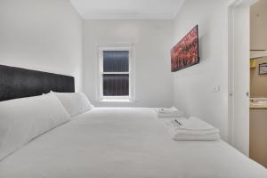 墨尔本Grosvenor 3121 Richmond的白色的卧室设有一张白色大床和一个窗户。