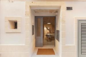 法萨诺[Exclusive - Suite] SPA con Idromassaggio Jacuzzi的走廊,门通往饭厅