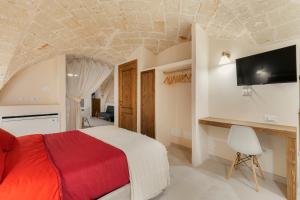 法萨诺[Exclusive - Suite] SPA con Idromassaggio Jacuzzi的卧室配有一张床,墙上配有电视。