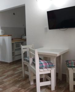 格塞尔镇Mono Yoly的厨房配有白色的桌椅和电视。